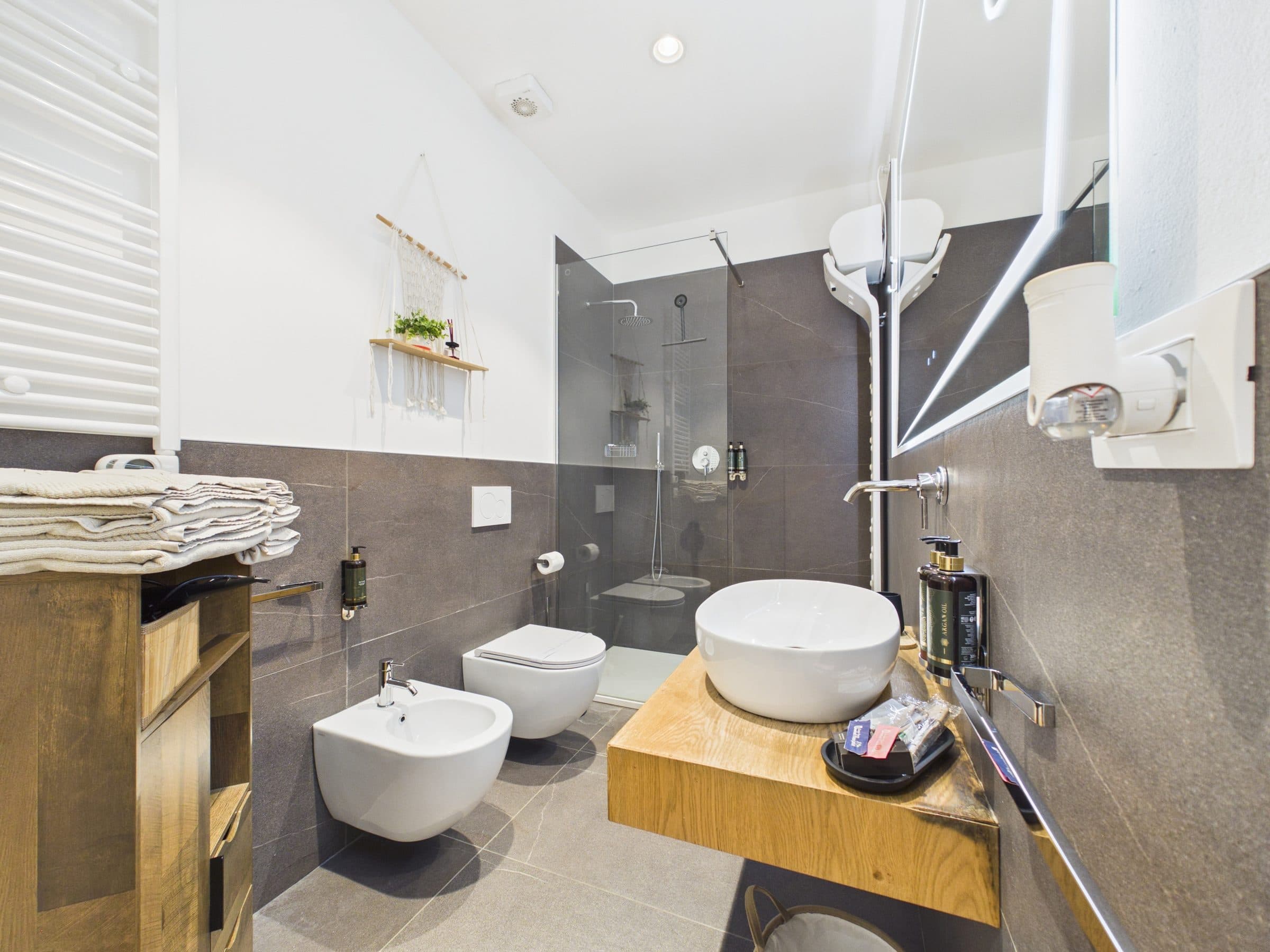 Bagno con doccia e mensole in legno
