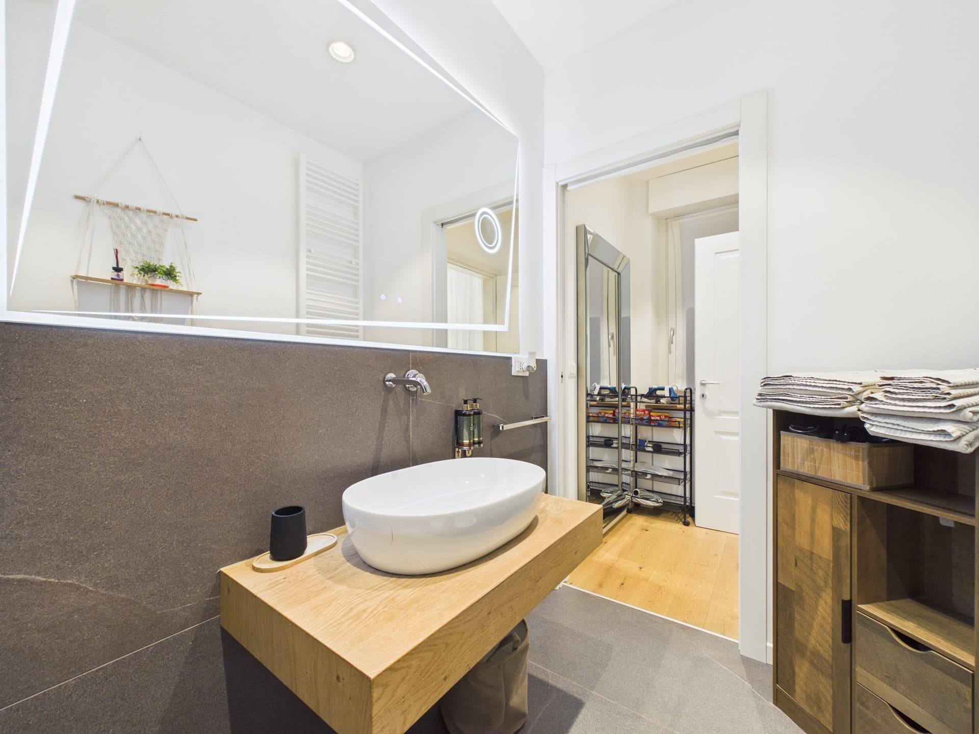 Bagno con doccia e mensole in legno
